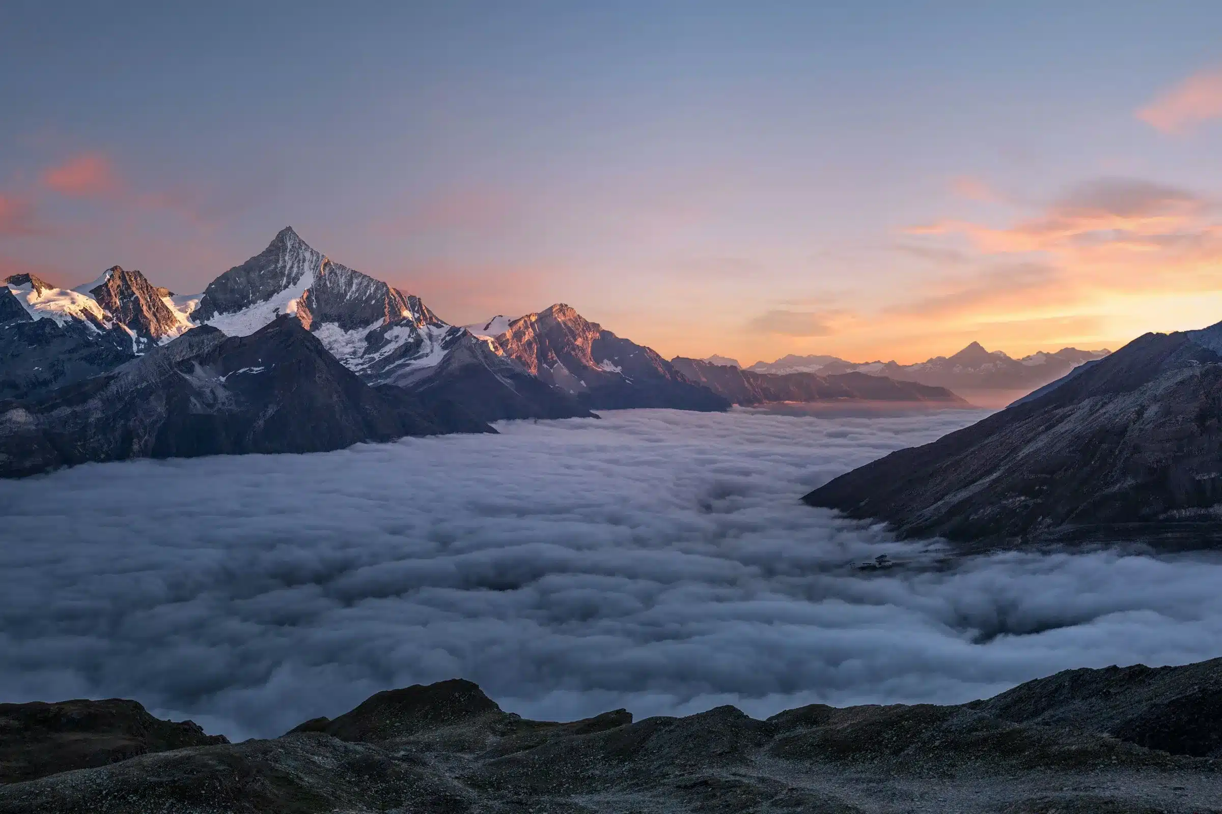 Montagnes dans la lumière bleue du crépuscule, une lueur dorée à l’horizon